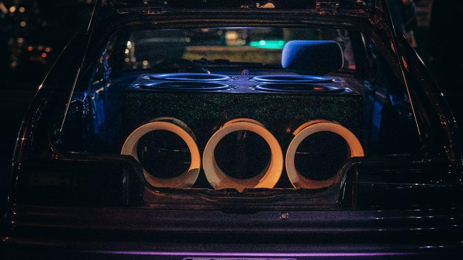 Large car audio speakers and subwoofers in a car boot with LED lighting - PMPO vs RMS watt lie guide for Indian car audio 2026, how to read real amplifier power