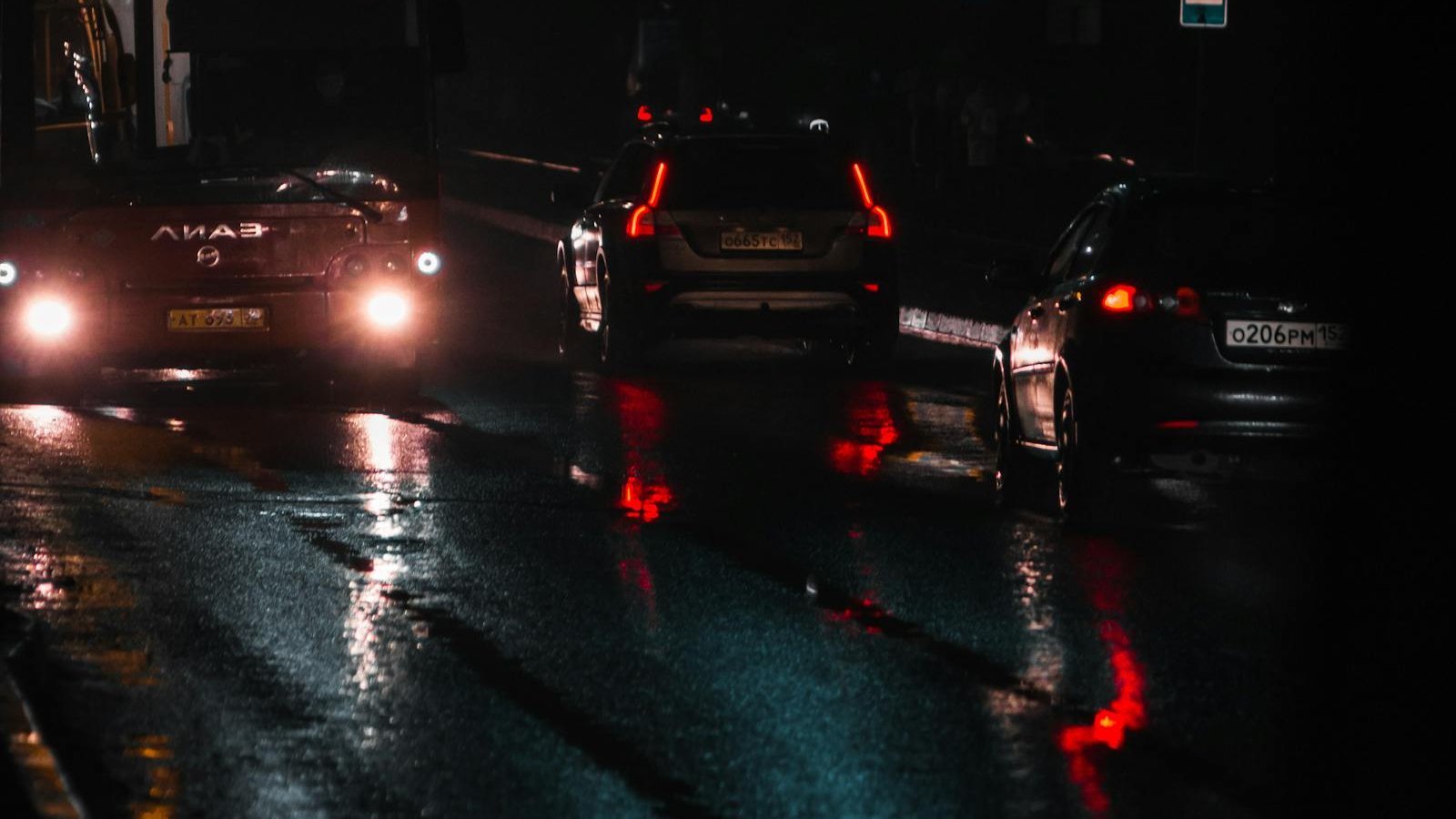 Cars with headlights on a wet road at night in India - LED headlight glare problem and projector retrofit fix 2026, reflector housing scatter and monsoon visibility