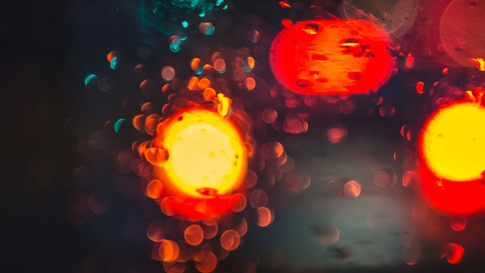 Blurred night traffic lights through a rain-covered car window - why dash cam footage fails at night and in monsoon, Sony STARVIS sensor HDR and bitrate over 4K resolution, India 2026