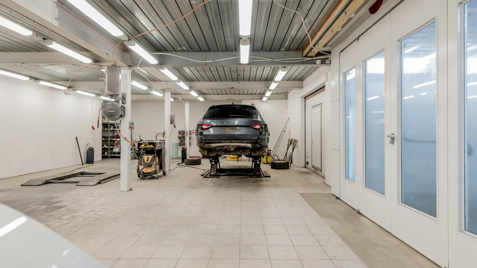 Car accessory shop trust checklist India 2026 - clean professional workshop bay with car on lift, organized tools, the workshop tour test for vetting installers
